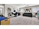 Spacious living room featuring neutral paint, a workstation, a dark sofa, and comfortable carpet at 10426 Mount Washington Ave, Las Vegas, NV 89166