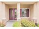 Inviting entryway with a decorative glass door, sidelight, and complementary maroon shutters at 1100 Cypress Ridge Ln, Las Vegas, NV 89144