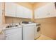Well-organized laundry room with white cabinets, sink, washer, and dryer at 1100 Cypress Ridge Ln, Las Vegas, NV 89144