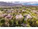 Stunning aerial view of a luxury home in a lush, green community with mountain views at 12056 Royal Dolnoch Ct, Las Vegas, NV 89141