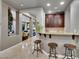 A cozy bar area with granite countertops, dark wood cabinets, and seating at 12056 Royal Dolnoch Ct, Las Vegas, NV 89141