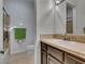 Bathroom featuring neutral tile, framed mirror, vanity with sink, toilet, and tiled shower at 12056 Royal Dolnoch Ct, Las Vegas, NV 89141