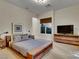 Well-lit bedroom featuring a neutral palette, soft carpet, window views and a large television at 12056 Royal Dolnoch Ct, Las Vegas, NV 89141