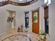 Bright foyer with a decorative stone floor, wooden door with glass, and elegant staircase entrance at 12056 Royal Dolnoch Ct, Las Vegas, NV 89141