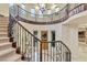 Grand foyer features a staircase with wrought iron railing and decorative glass front door at 12056 Royal Dolnoch Ct, Las Vegas, NV 89141