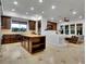 Gourmet kitchen featuring granite countertops, custom cabinets, and a large center island and adjacent living area at 12056 Royal Dolnoch Ct, Las Vegas, NV 89141