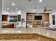 Spacious open-concept living room with a fireplace and large windows, open to the kitchen at 12056 Royal Dolnoch Ct, Las Vegas, NV 89141