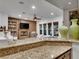 Open-concept living room with a cozy fireplace, built-in shelving, and large windows at 12056 Royal Dolnoch Ct, Las Vegas, NV 89141