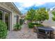 Charming outdoor dining area on a stone patio, surrounded by lush greenery and landscaping at 12056 Royal Dolnoch Ct, Las Vegas, NV 89141