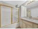 Bathroom featuring a tub-shower combo with glass doors and a vanity with granite countertop and stylish fixtures at 1221 Diamond Valley St, Henderson, NV 89052