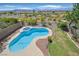 Aerial view of a private pool and spa with a manicured yard, concrete deck, and desert landscape beyond the fence at 1221 Diamond Valley St, Henderson, NV 89052