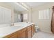 Bathroom featuring a double sink vanity, large mirror with lights, and shower with glass door at 1287 Dove Tree Ct, Henderson, NV 89014