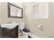 Cozy powder room with a dark vanity, toilet, and mirror in a neutral-toned setting at 1287 Dove Tree Ct, Henderson, NV 89014