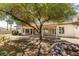 Spacious backyard featuring a mature shade tree, rock feature, and partial view of covered patio space at 1454 Erskine Ave, Las Vegas, NV 89123