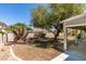 Backyard featuring lush plants, rock features, partial grass coverage, and covered patio at 1454 Erskine Ave, Las Vegas, NV 89123