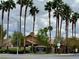 View of community entrance with landscaping, signage, and palm trees on a cloudy day at 1454 Erskine Ave, Las Vegas, NV 89123