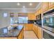 Well-lit kitchen with granite countertops, stainless steel appliances, and wooden cabinets at 1454 Erskine Ave, Las Vegas, NV 89123