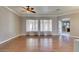 Open-concept living room features hardwood floors, large windows and ceiling fan at 1454 Erskine Ave, Las Vegas, NV 89123