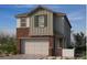 Two-story home with brick and siding, complemented by a two-car garage and well-manicured landscaping at 148 Silver Run Lane, Las Vegas, NV 89138