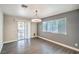 A naturally lit dining room features a modern light fixture, sliding glass door, and updated flooring at 1574 Teardrop St, Las Vegas, NV 89142