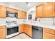 Traditional style kitchen with oak cabinets, white tile countertops and modern appliances at 1751 E Reno Ave # 206, Las Vegas, NV 89119