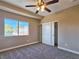 A well-lit bedroom with neutral carpet, ceiling fan, and a sliding door closet at 1851 Hillpointe Rd # 2124, Henderson, NV 89074