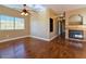 Open living room with hardwood floors, large windows, ceiling fan, and stone fireplace at 1851 Hillpointe Rd # 2124, Henderson, NV 89074