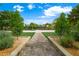 Brick pathway to community basketball court with lush landscaping and trees, inviting residents to enjoy outdoor activities at 2325 Prometheus Ct, Henderson, NV 89074