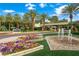 Welcoming community entrance with fountains, colorful flower beds, mature palm trees, and a guard house at 2325 Prometheus Ct, Henderson, NV 89074