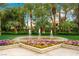 Landscaped community area showcasing water fountains, colorful flower beds, and mature palm trees at 2325 Prometheus Ct, Henderson, NV 89074