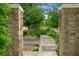 Stone entrance with wrought iron archway leads to paved street lined with trees and flowering shrubs at 2325 Prometheus Ct, Henderson, NV 89074