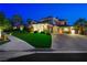 Elegant two-story home with brick facade and lush landscaping at twilight at 2325 Prometheus Ct, Henderson, NV 89074