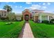 Elegant home with brick accents, a well-manicured lawn, and mature landscaping at 2325 Prometheus Ct, Henderson, NV 89074