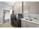 Laundry room with modern washer/dryer, sink, and ample storage at 2325 Prometheus Ct, Henderson, NV 89074