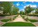 Beautifully landscaped neighborhood featuring trees, sidewalks, and well-manicured greenery with blue skies at 2325 Prometheus Ct, Henderson, NV 89074