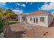 Large backyard with gravel, small turf area, and patio area, with white stucco walls and a red tile roof at 2588 Mizzoni Cir, Henderson, NV 89052