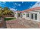 A spacious backyard with minimal landscaping, a small patch of grass, and a stone tiled patio at 2588 Mizzoni Cir, Henderson, NV 89052