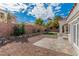 Backyard featuring gravel, artificial turf, and tiled patio area with a low block wall along the back at 2588 Mizzoni Cir, Henderson, NV 89052