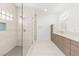 Elegant bathroom featuring glass-enclosed shower with mosaic floor and dual sink vanity with modern finishes at 2588 Mizzoni Cir, Henderson, NV 89052