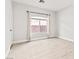 Bright bedroom with a window featuring neutral walls, wood-look tile flooring, and privacy enhancing curtains at 2588 Mizzoni Cir, Henderson, NV 89052