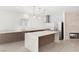 Modern kitchen featuring a large island, stainless steel appliances, and a cozy fireplace at 2588 Mizzoni Cir, Henderson, NV 89052
