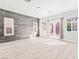 Bright living room featuring wood-look floors, a gray accent wall, and natural light from windows and French doors at 2588 Mizzoni Cir, Henderson, NV 89052