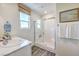 Bright bathroom features a glass-enclosed shower, modern sink, and a large window for natural light at 2641 Begonia Falls Ave # 88, North Las Vegas, NV 89081