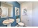 Half bath features a white vanity with brushed nickel hardware, blue accent wall and decorative art at 2641 Begonia Falls Ave # 88, North Las Vegas, NV 89081