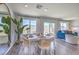 Bright dining area features a modern table setting, lots of windows, wood floors and an adjacent living area at 2641 Begonia Falls Ave # 88, North Las Vegas, NV 89081