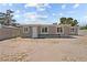 Rear view of the property showing neutral-toned siding, multiple windows, and a functional back door at 2712 Holmes St, North Las Vegas, NV 89030
