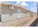 Exterior view of a stucco home with a door, windows, and a gravel-covered yard at 2712 Holmes St, North Las Vegas, NV 89030