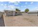 A wide shot of the expansive backyard with a view of the storage unit, gravel and exterior of the home at 2712 Holmes St, North Las Vegas, NV 89030