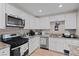 Well-lit kitchen featuring white cabinets, granite countertops, and stainless steel appliances at 2712 Holmes St, North Las Vegas, NV 89030