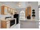 Efficient kitchen featuring wood cabinets, black appliances, and an arched window at 3150 Soft Breezes Dr # 2046, Las Vegas, NV 89128